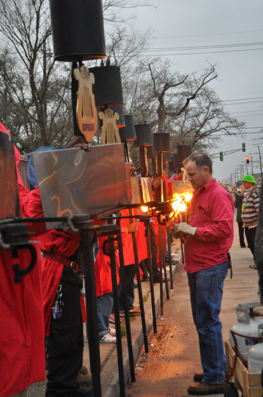 With the fire department looking on, the flambeaux carriers get lit up. 