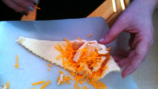 Step Three: Roll out your crescent rolls and sprinkle each with shredded chicken and shredded cheese