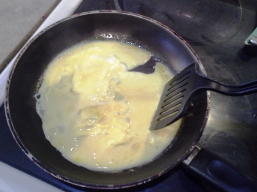 Step Six: Keep moving your egg around the pan with your spatula to mix and cook thoroughly