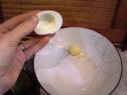 Step Eleven: Using your fingers to push from the back, push the yolks out into a mixing bowl