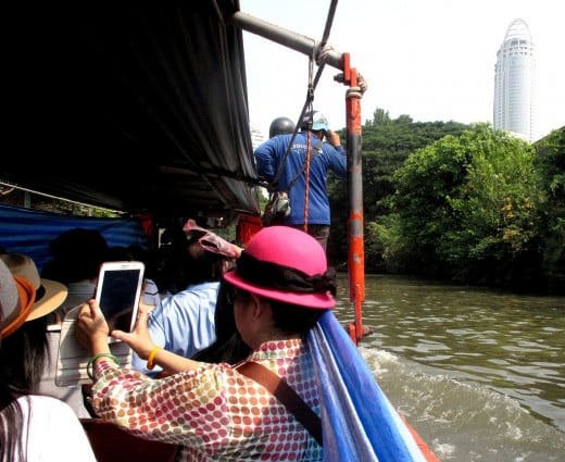 These Chinese visitors to Bangkok are enjoying their boat trip down Bangkok's less well known waterways...