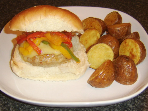 Fried bell peppers top a spicy pork cheeseburger which is served with deep fried red potato halves