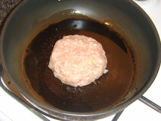 Starting to fry pork, sage and onion burger