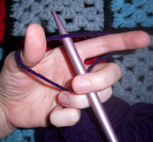 The needle fits under the yarn between thumb and forefinger like this.