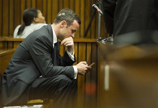 Oscar Pistorius on his cellphone during the trial and questioning of witnesses.