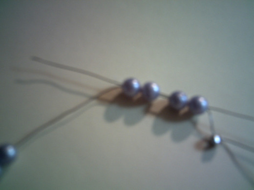 Insert the wire back through the first four beads.