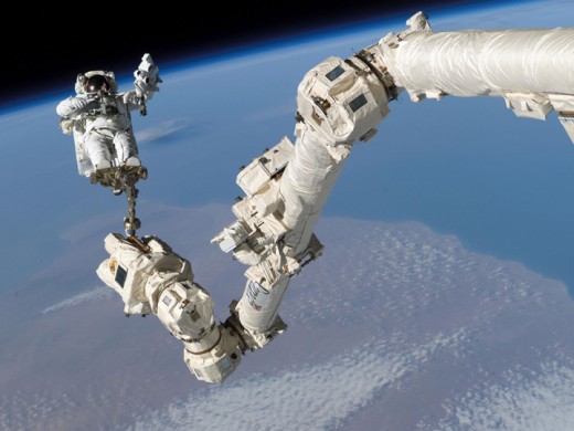 An astronaut working on his equipment in the outer space