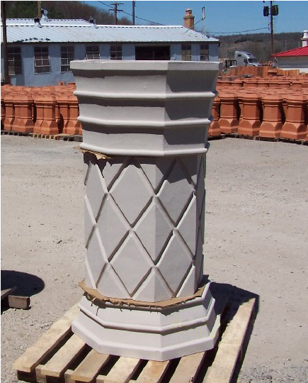 A finished clay chimney pot on a pallet.