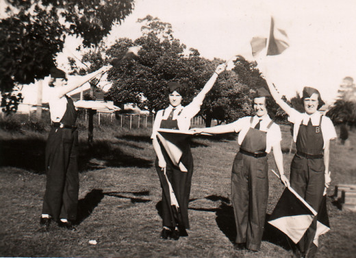 Ex-WRANs association of NSW, Dressed in the practical green uniforms designed by w:Florence Violet McKenzie, these Women's Emergency Signaling Corps members spell out W E S C with the semaphore flag signalling system, one of several signalling system