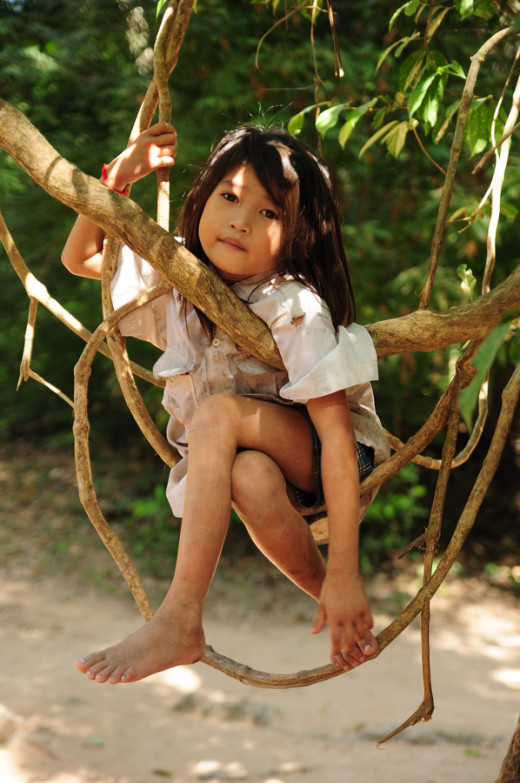  Show me the photo Photograph Little Girl sitting on a tree branch resting in Siem Reap, Cambodia by Anlun