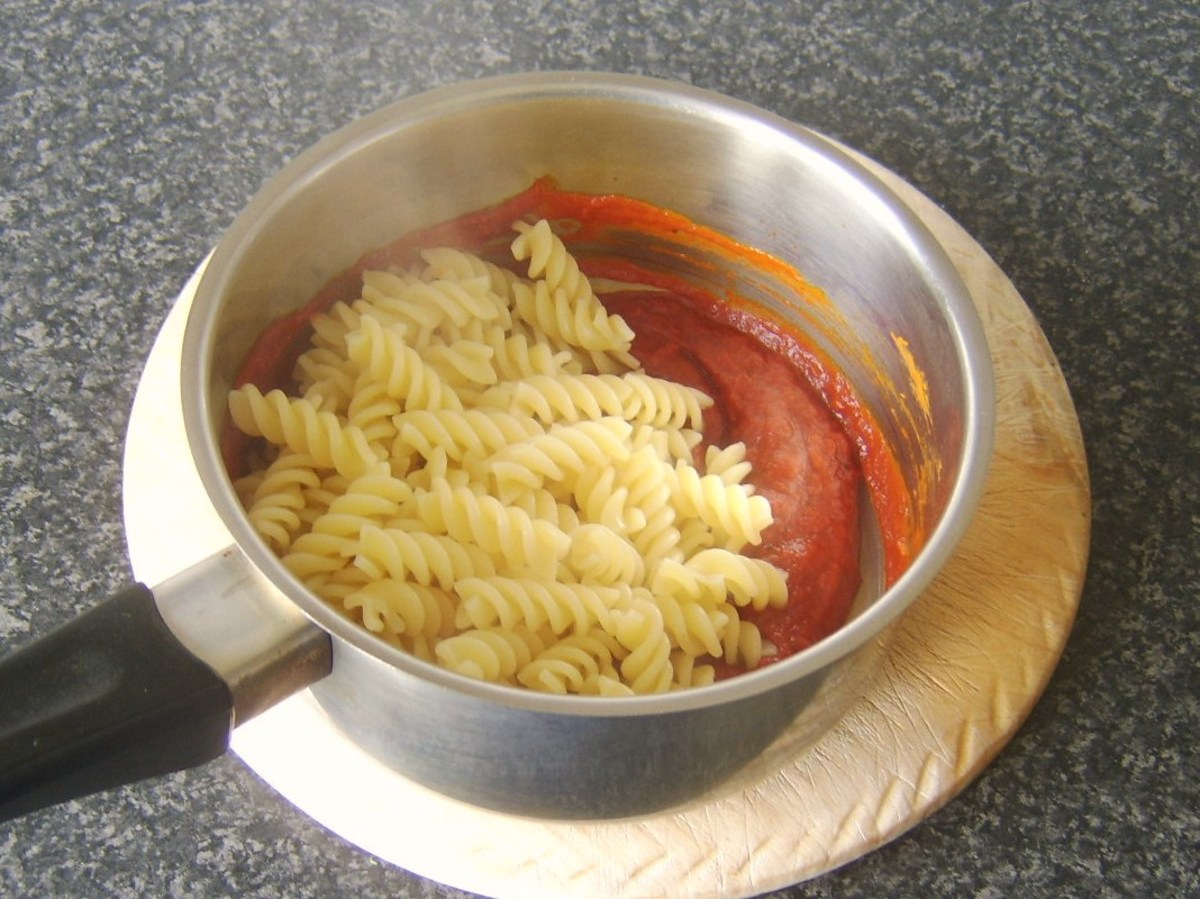 Fusilli pasta is added to heated sweet pepper and tomato sauce