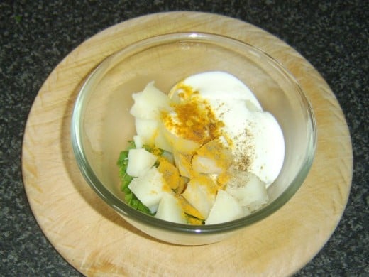 Combining spicy potato salad ingredients