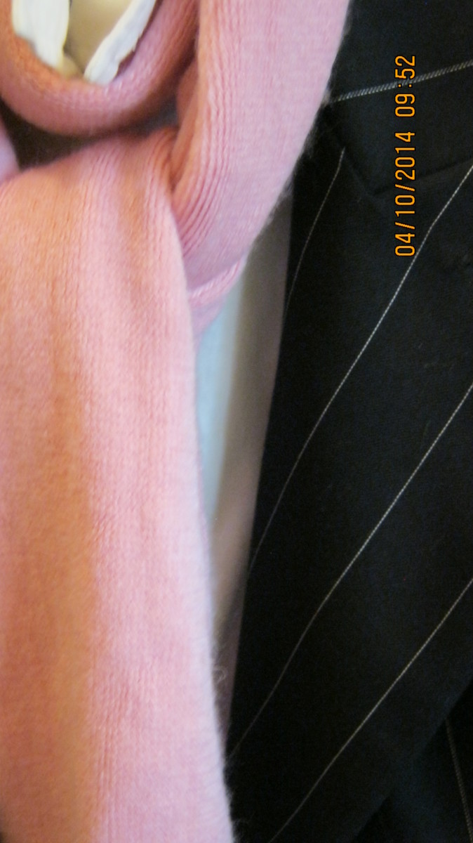 Pinstriped Norma Kamali jacket over white button-down shirt and accessorized with a pink scarf.