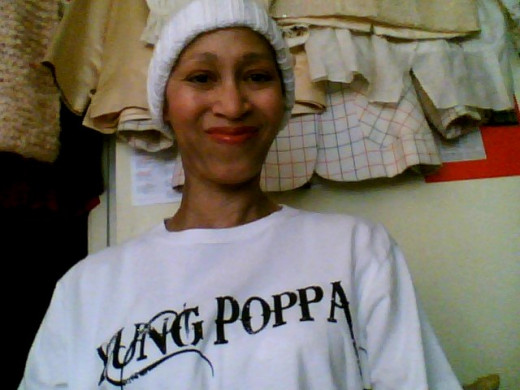 Victoria Moore in a "Yung Poppa" t-shirt and a white knit cap made by Sylvia A. from Koloa, Hawaii for "The Giving Caps Group".
