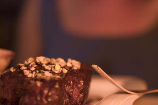 Steak covered in chocolate with pistachios.
