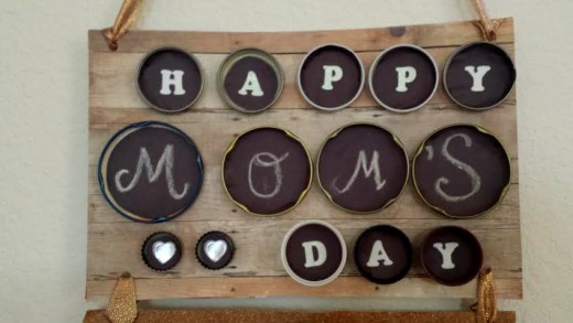My little girl enjoyed creating this Mother's Day gift with me.  I used black construction paper and white chalk to give it that chalkboard effect for the middle row that reads, "Mom's."  I used white letter stickers for the other words.