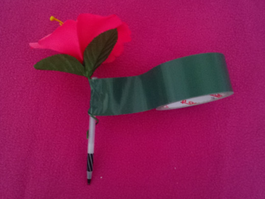 You can use green duct tape, or any type you choose. There are lots of choices out there. Wrap the flower wire around the pen to secure it. Then wrap the duct tape around it from tip to tip.