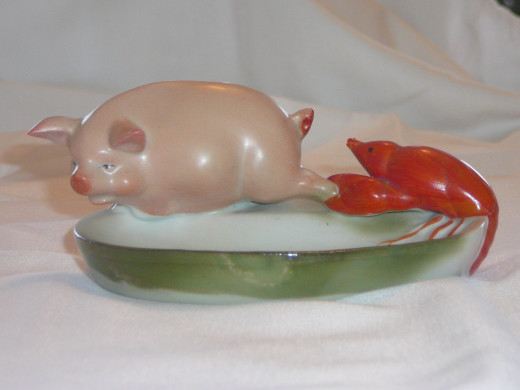 Lobster catching a pigs foot pin dish. This figurine is shown in the book "This little piggy" and its '92 value was $75. 5" x 4". Paid $162. Rare, 