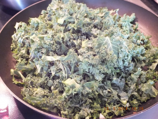 I removed the onions and set them aside in a bowl. Using the same pan that you sauteed the onions in, add the kale, water and Bragg's amino acids or soy sauce.