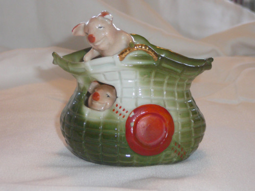 One piggy looks out of the porthole while another perches atop of this ornate basket with a rouge cachet circle. Featured in "This lithe Piggy" its '92 value was $60. 3" x 3". Paid $33. Rare.