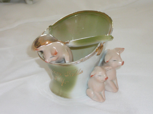 3 pigs with a cup and spoon. This is considered to be a mustard cup. The inscription Niagra Falls NY was added in an American Factory. It's the only one I've seen to date on ebay.  4" x 3". Paid $61 Rare
