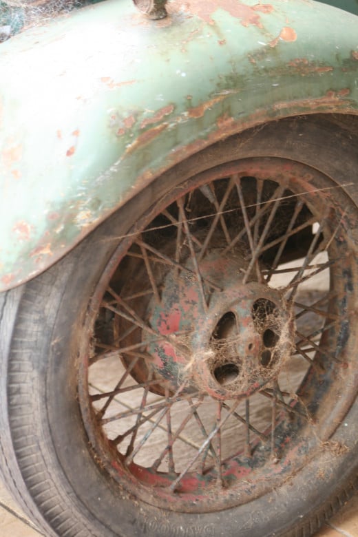 Original old wheel before any effort was made to restore the vintage vehicle. Hints of red paint remain.