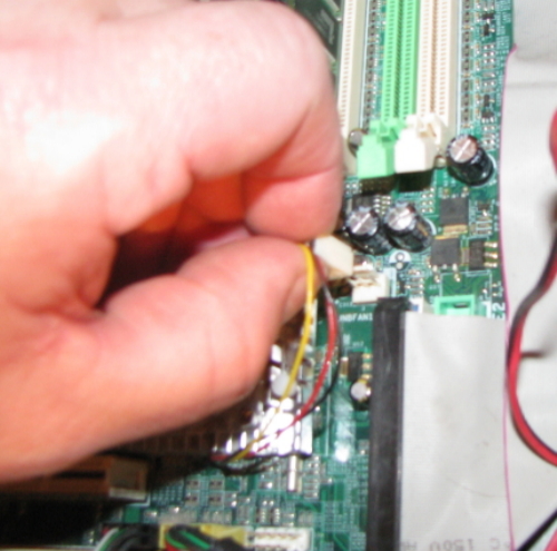 Unplugging the fan from the motherboard. Unplugging the fan from the motherboard.