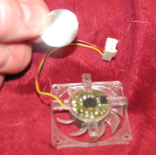The black piece of hard rubber under the sticker is the bearing dust cover. The black piece of hard rubber under the sticker is the bearing dust cover.