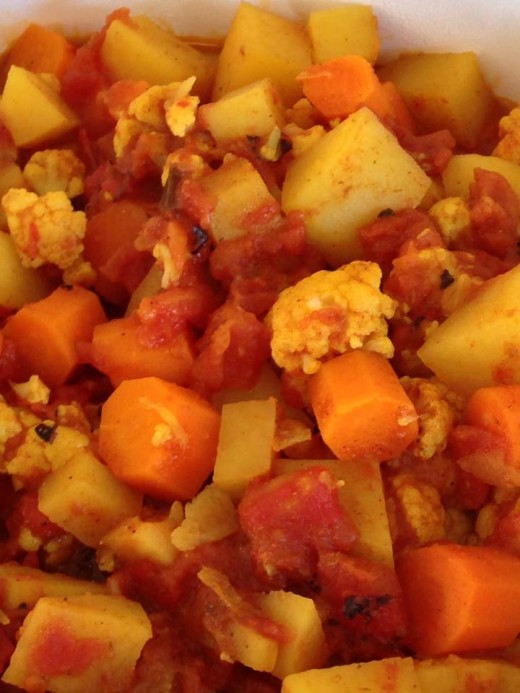 Stew the vegetables with the curry in a tomato base. Here, I used cauliflower, carrots and potatoes, but leafy greens and broccoli are good, as well. Add softer vegetables later in the cooking process for uniform doneness.