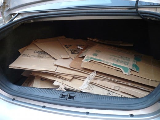 The car trunk is full of cardboard for the garden