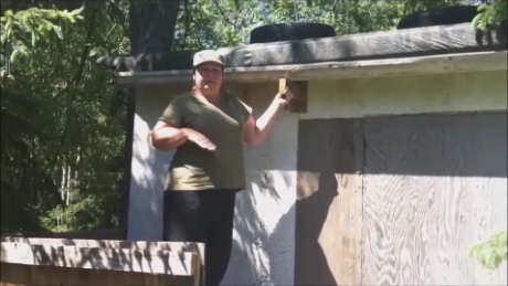 Fastening a used eavestrough with homemade wooden supports.