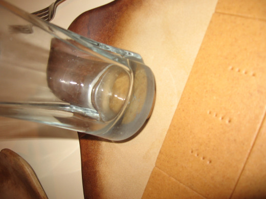 Press a cherry-sized amount of dough with a glass to create round crackers.  