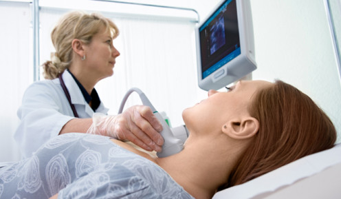 A noninvasive cardiovascular technologist performing a routine echocardiogram on a patient
