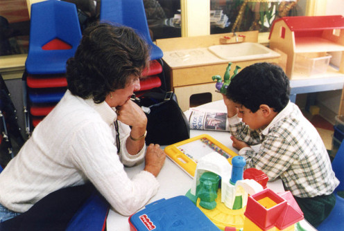 A special education teacher provides assistance to one of her students.