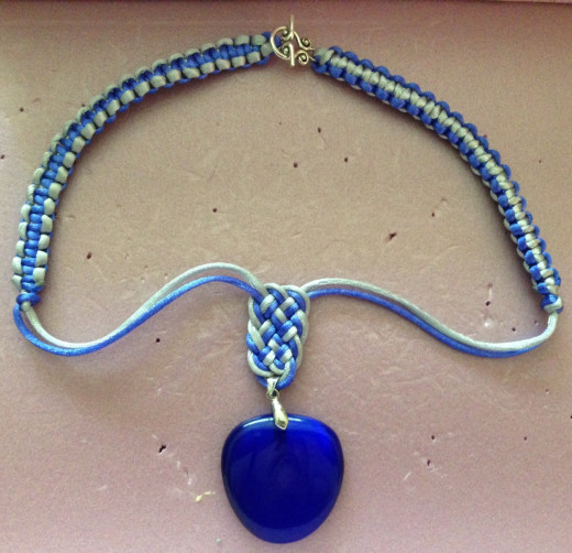 Prosperity knot pendant necklace with one side of square knots color reversed.