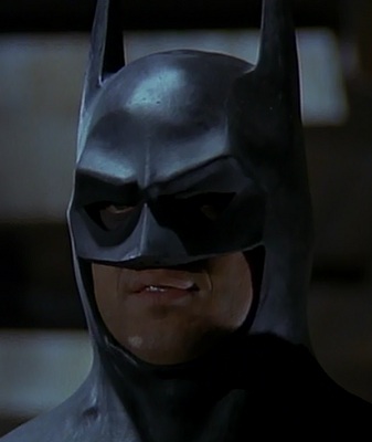 Michael Keaton as Batman sporting his trademark Batman smile.