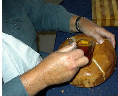 Then he pours a bit of wine so that it touches all four pieces of the bread before he breaks it.