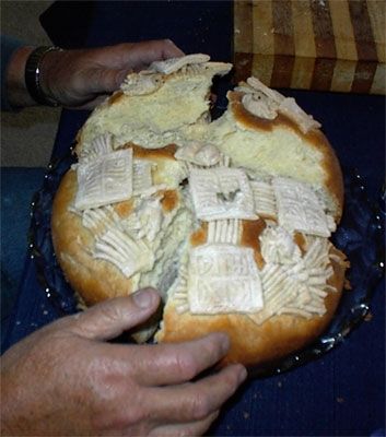 Kosta breaks the bread.