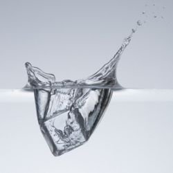 "Ice cube splashing in water"