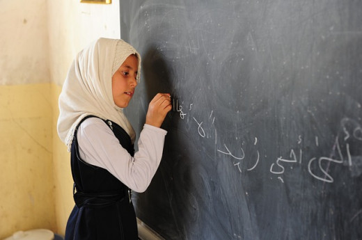 Girl writing on board in Iraq.