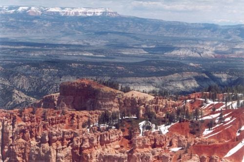 Bryce Canyon. Red rocks, snow, distant mountains, and a sunny day with just enough clouds.