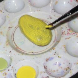 Painting a rock yellow.