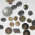 An assortment of metal buttons. All of these metal buttons are decorative and all but one has a shank at the back so all of the button's beauty shows.