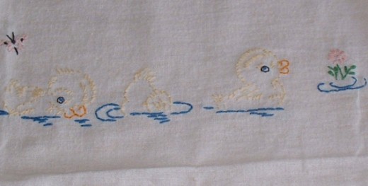 Embroidered ducks on tea towel.