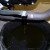 Let the oil drain into the pan. Move the Grom to an upright position until the remaining oil trickles out.