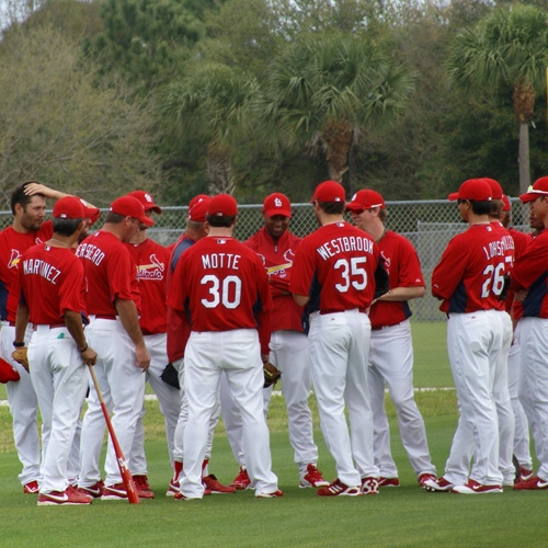Pitchers gather round for instructions prior to the start of pitching practice.