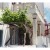 Another view of Mykonos' many winding streets. The grape trellis at left shades the entrance to a tiny art museum.