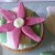 Cut out daisy petal shapes in pink fondant and arrange into a flower shape, with a white fondant centre Cut out daisy petal shapes in pink fondant and arrange into a flower shape, with a white fondant centre