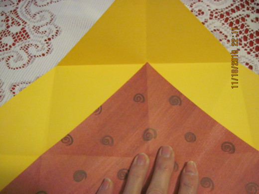 Fold each corner to the first fold of the opposite corner.