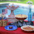 The utensils, plates, and some of the food on the left side of the table. The utensils, plates, and some of the food on the left side of the table.